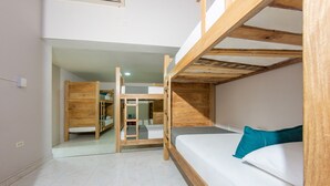 A bunk bed room with a wooden ladder, a white mattress, and a teal pillow.