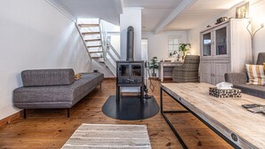 Una sala moderna con un sofá, una mesa de centro de madera y una chimenea.