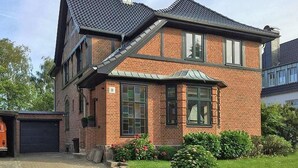 A two-story house with a brick exterior, a garage, and a well-maintained garden. - fewo1846 - Home port Flensburg - fewo1846 - Home port Flensburg / elegant (Flensburg)