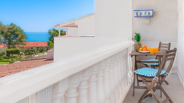A balcony with a table set for two, featuring a pineapple and oranges. - Top Apartment with Sea View and Pool (el Gran Alacant)
