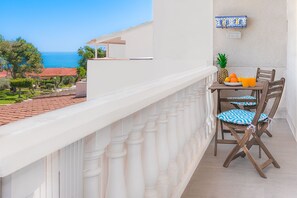 A balcony with a table set for two, featuring a pineapple and oranges. - Top Apartment with Sea View and Pool (el Gran Alacant)
