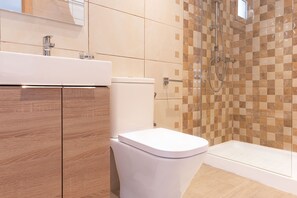 A modern bathroom with a wooden vanity, a white toilet, and a shower area with checkered tiles. - Top Apartment with Sea View and Pool (el Gran Alacant)