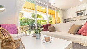 A cozy living area with a sofa, a wicker chair, a coffee table, and a view of the outdoors. - Magnífica duplex renovado con piscina garaje y jardín, frente a la playa de... (Los Caños de Meca)