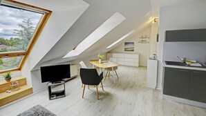 A modern loft apartment with a dining area, kitchen, and a large skylight. - fewo1846 - Beach shell (App. 638) / Studio apartment with sea view on the 3rd floor - (Harrislee)