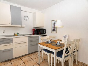 A compact kitchen with a microwave, coffee maker, and a clock on the wall. - fewo1846 - Little Mermaid (App. 666) / Studio apartment on the top floor - (Harrislee)