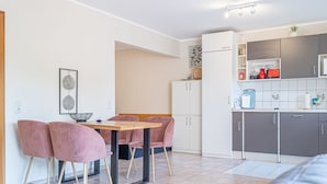 A compact living space with a dining area, kitchenette, and a small seating area. - fewo1846 - Fördeblick I (App. 670) / Studio apartment with balcony on the mezzanine floor (Harrislee)