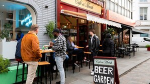 An outdoor seating area of Café del Marsh with tables and chairs, a sign indicating it is a beer garden, and a white van parked nearby. - Open plan Waterloo, 1BR, New build, terrace, by Blueground (London)