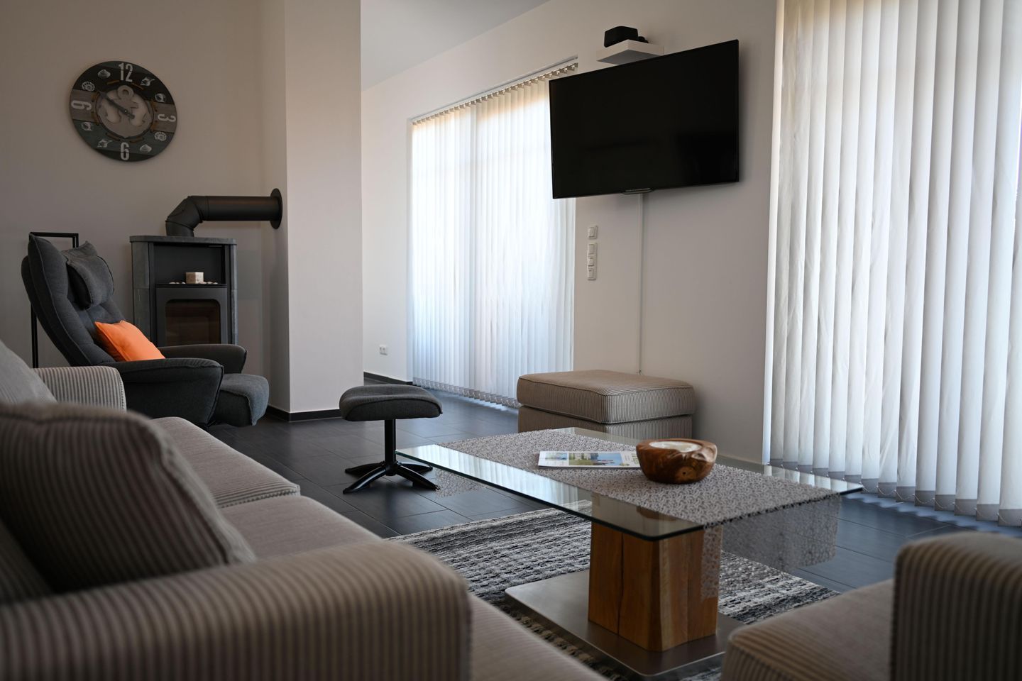 Una sala de estar moderna con un sofá, una mesa de centro, un televisor y una chimenea.