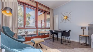 Un soggiorno moderno con una grande finestra, un'area pranzo e una bussola fissata al muro.