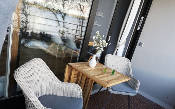 Un pequeño comedor con una mesa de madera y dos sillas de mimbre.