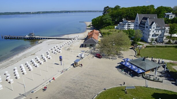 A beachside hotel with a sandy beach, a pier, and a large building with multiple stories. - fewo1846 - Rooftop (App. 604) elegant studio apartment with balcony and sea view (Glücksburg (Ostsee))