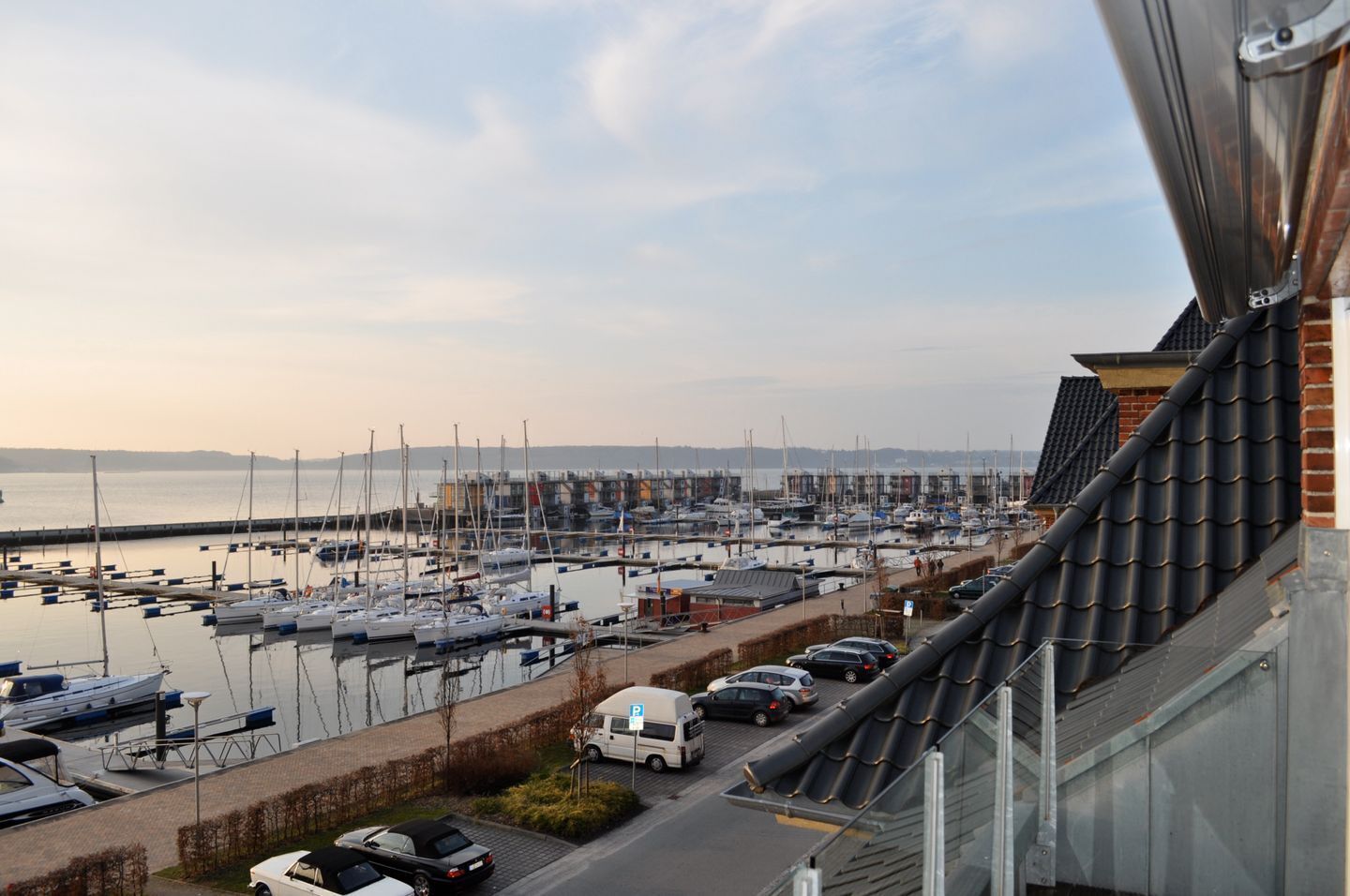 Un port de plaisance avec des bateaux amarrés, un espace de stationnement et une vue sur l’eau.