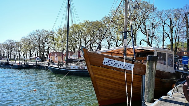 A wooden boat named 'Berta' docked at a marina with other boats, surrounded by trees and a clear sky. - Vacation apartment "Don't forget mine" - Holiday apartment "Don't forget mine" - (Putbus)