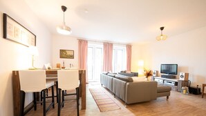 A modern living room with a sofa, TV, and dining area. - Vacation apartment "Don't forget mine" - Holiday apartment "Don't forget mine" - (Putbus)