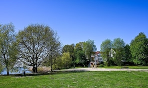 Un parc avec une aire de jeux, un banc et un bâtiment en arrière-plan.