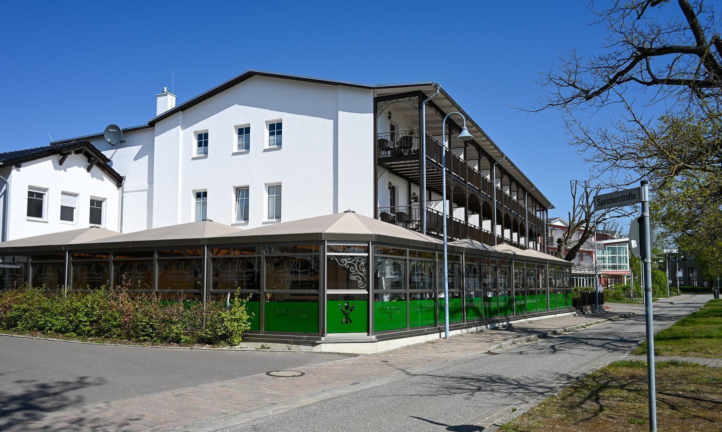 Un edificio blanco con un espacio exterior cubierto y un balcón.