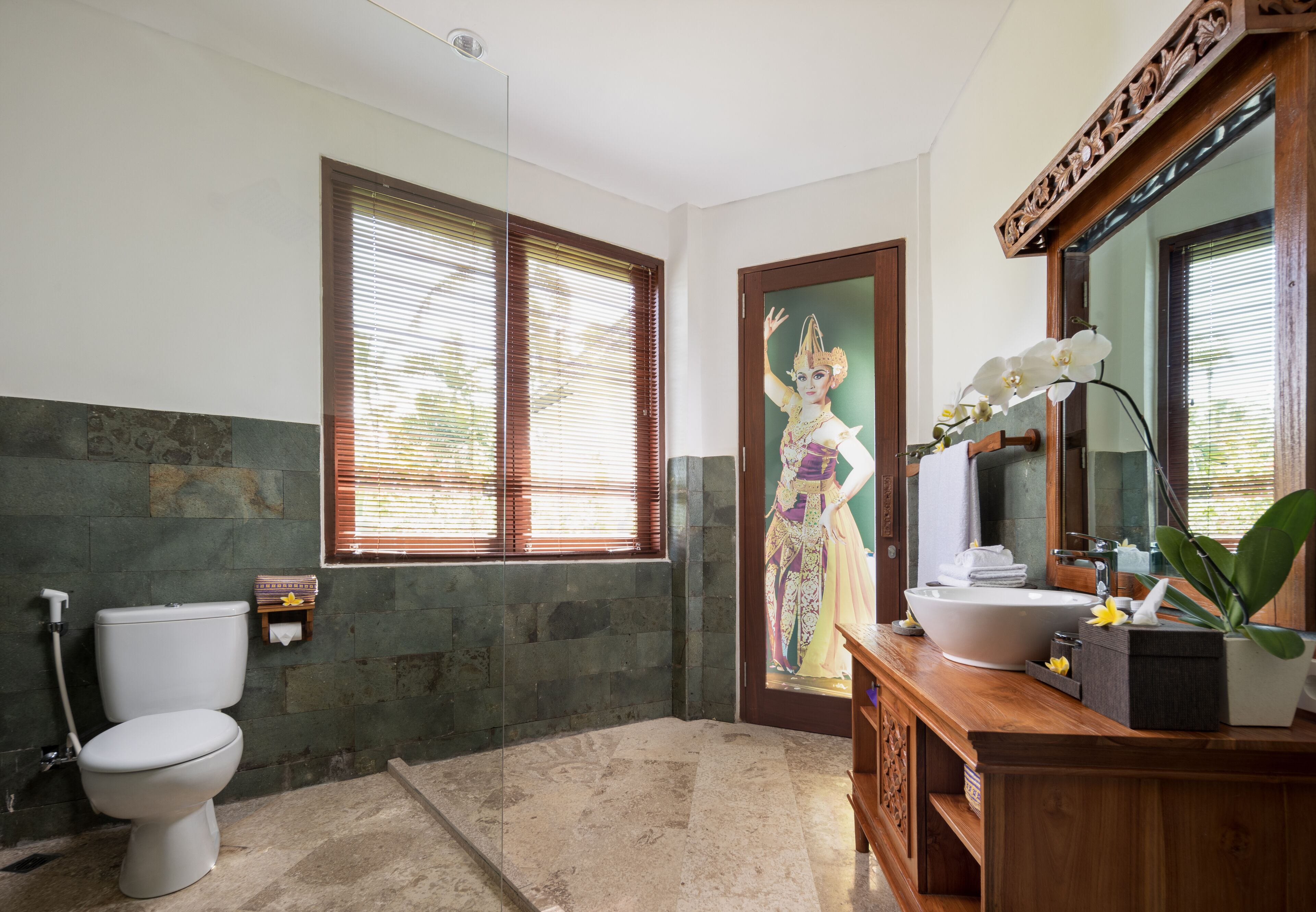 A bathroom with a toilet, sink, and large mirror.