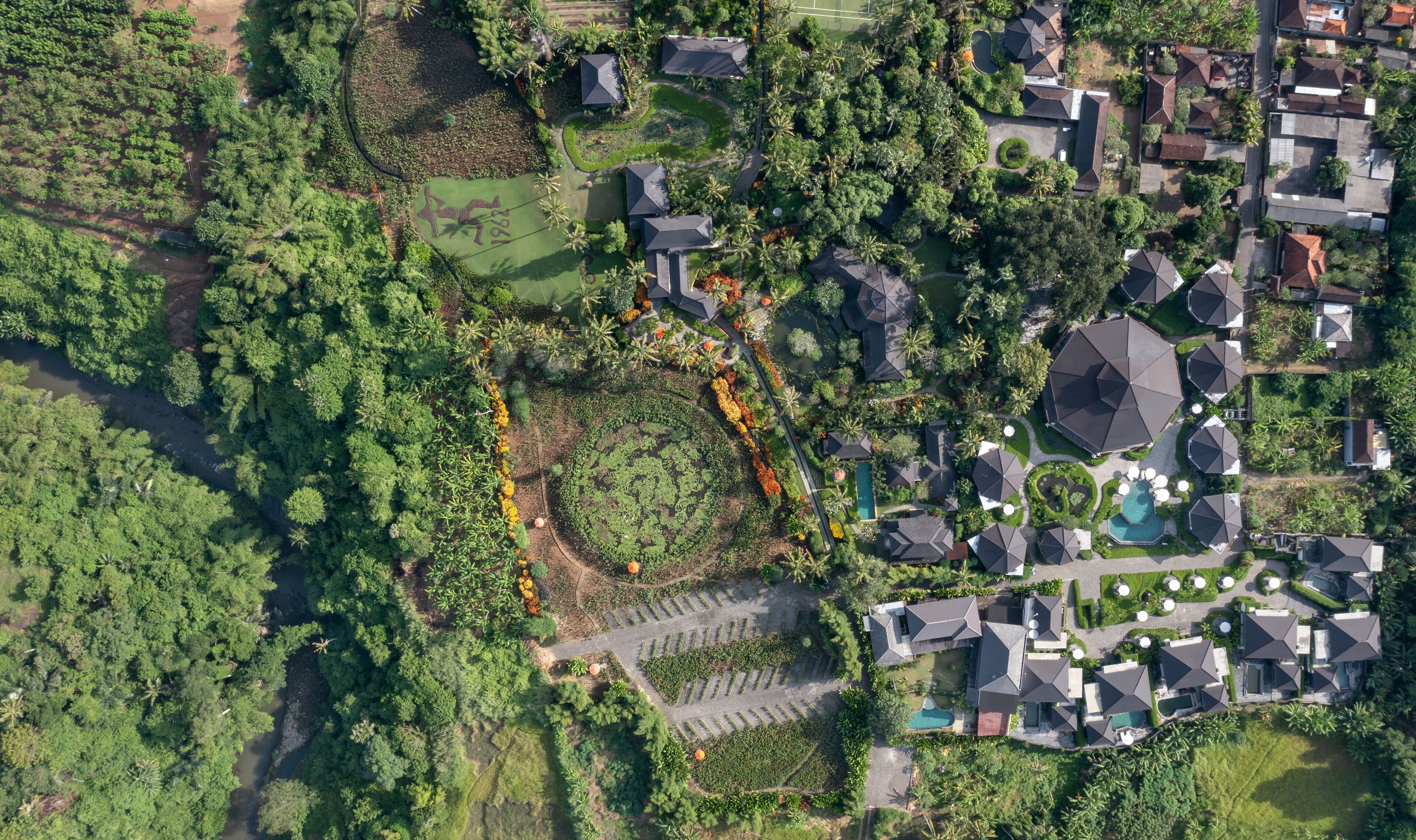 Vista aérea de una zona residencial con casas, un campo de golf y una piscina.