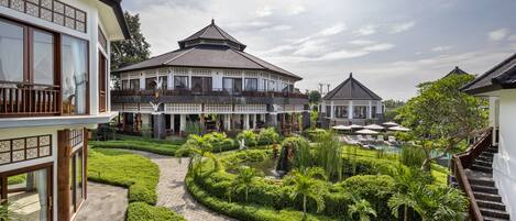 Edifício de estilo tradicional com um pátio central, rodeado por jardins bem cuidados e zona de piscina.