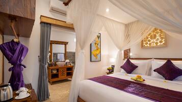 A hotel room with a bed, a vanity with a mirror, a wooden dresser, and a bathroom with a shower curtain.
