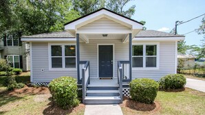 A two-story house with a front porch, a central door, and two windows on each side.