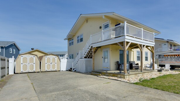 A two-story house with a balcony, a covered porch, and a garage. - Brigantine Condo w/ Gas Grill - Walk to Beach! (Brigantine)