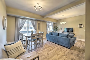 Relax in this stylish living room with a comfortable sofa, dining area, and ample lighting.