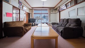 Ein Wohnzimmer mit zwei Sofas, einem Holztisch und einem Fernseher.