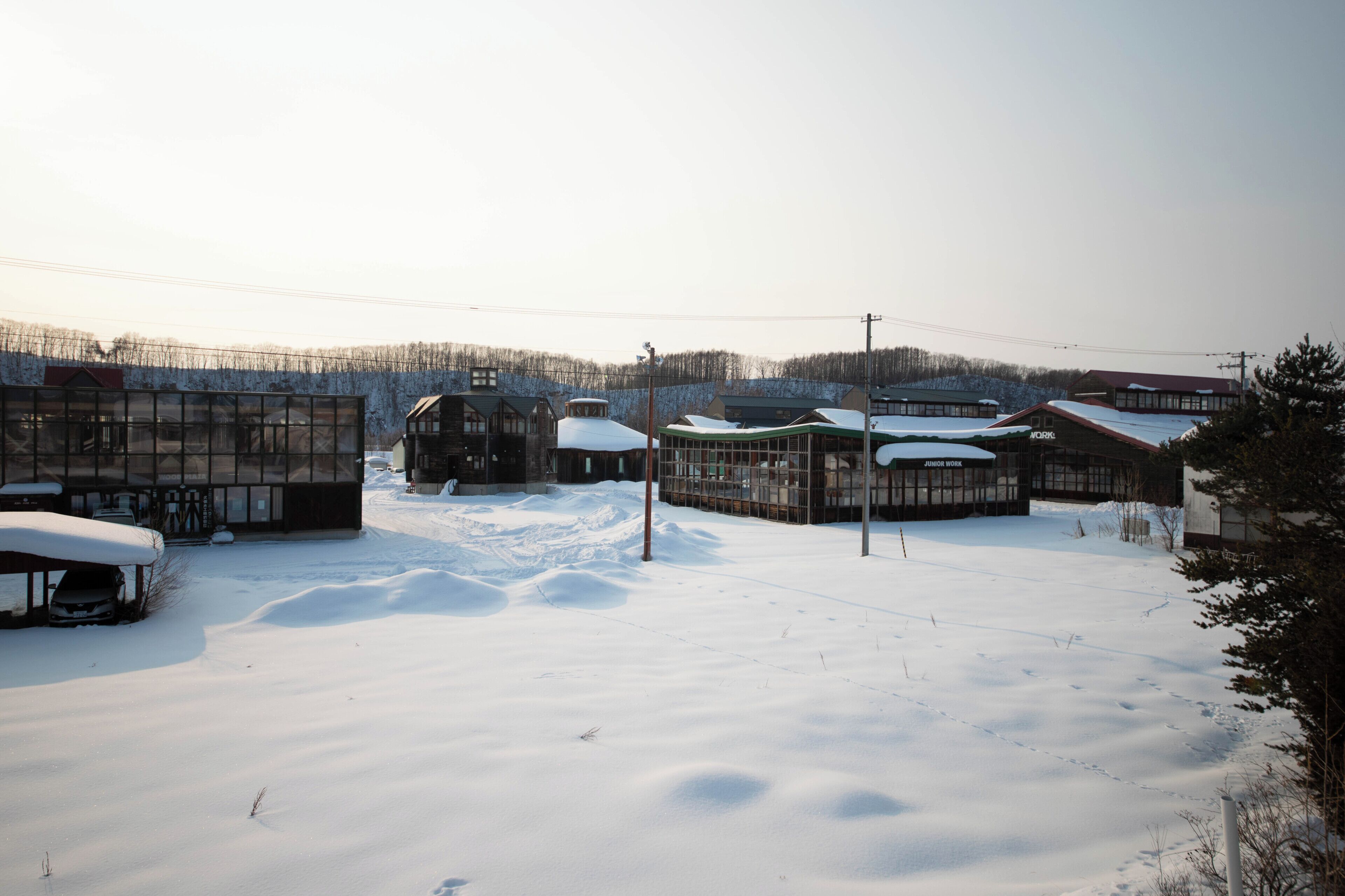 A snow-covered outdoor area with several buildings, including a structure labeled 'Junior Work.'