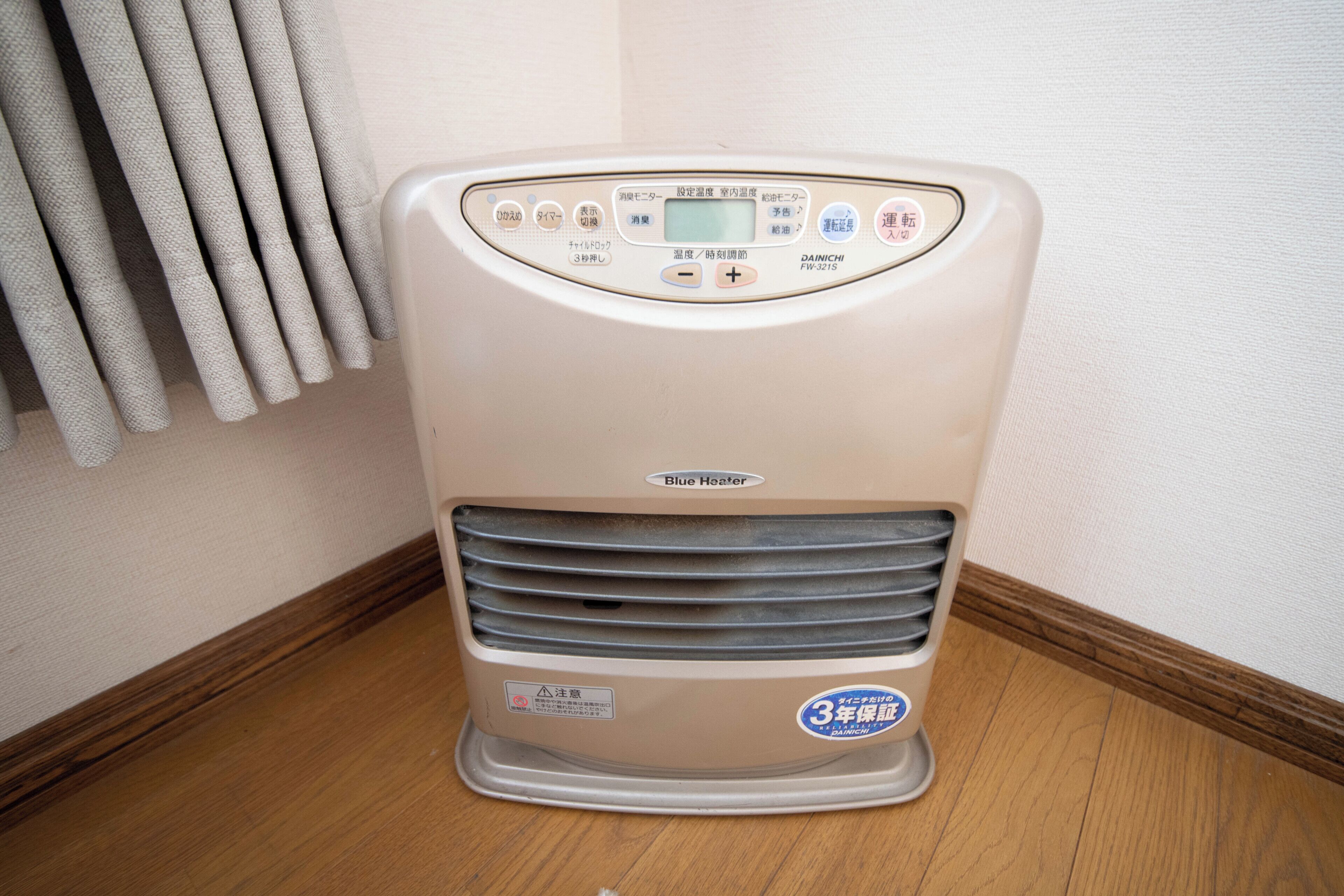 A white portable heater with a digital display, control buttons, and a '3-year warranty' label.