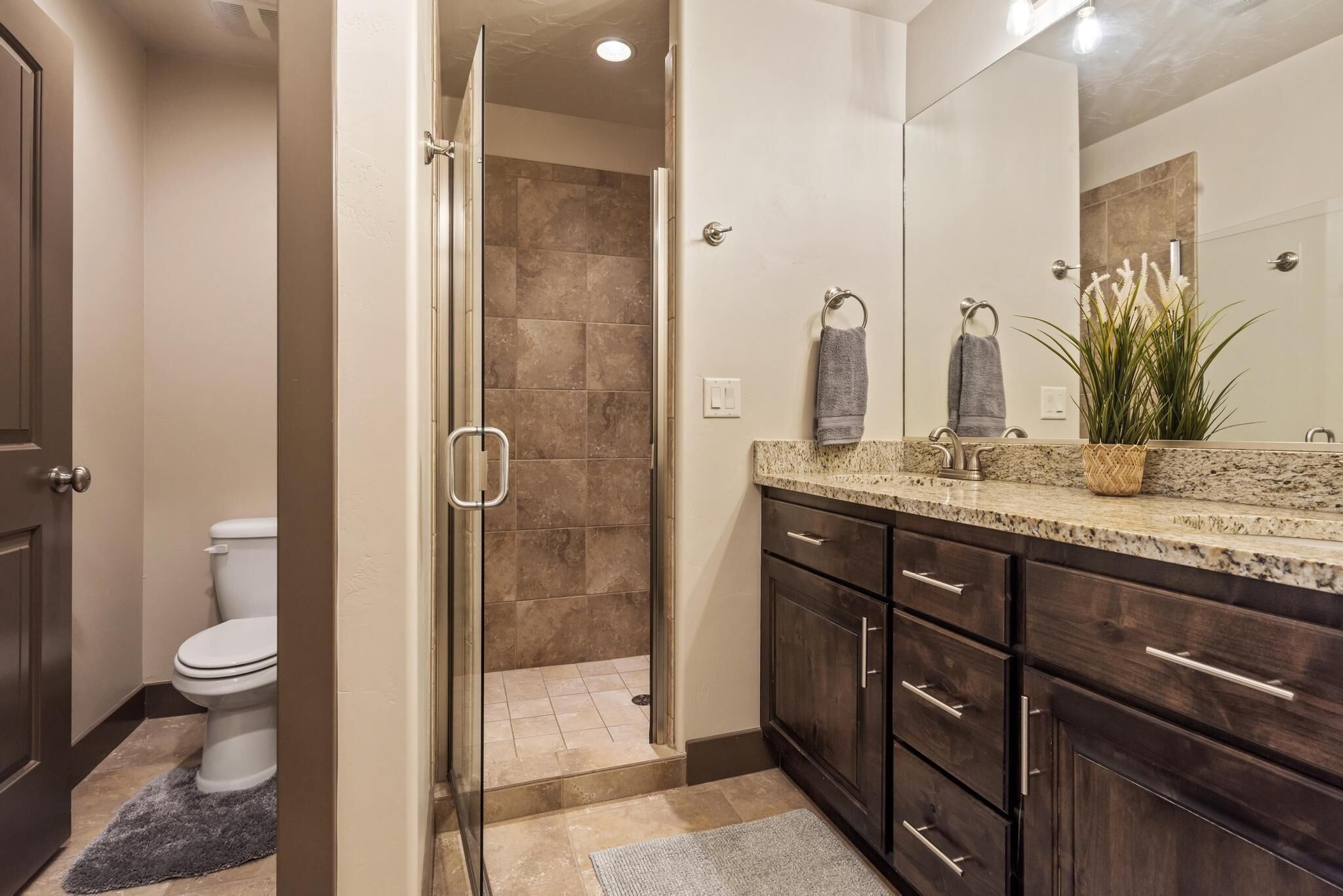 Un baño moderno con ducha, inodoro y tocador.
