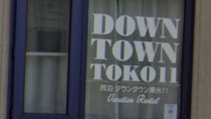 Ein Fenster mit dem Text "DOWN TOWN TOKOI" und "Ferienwohnung".