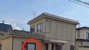 Ein zweistöckiges Gebäude mit einem 'Down Town'-Schild an der Seite.
