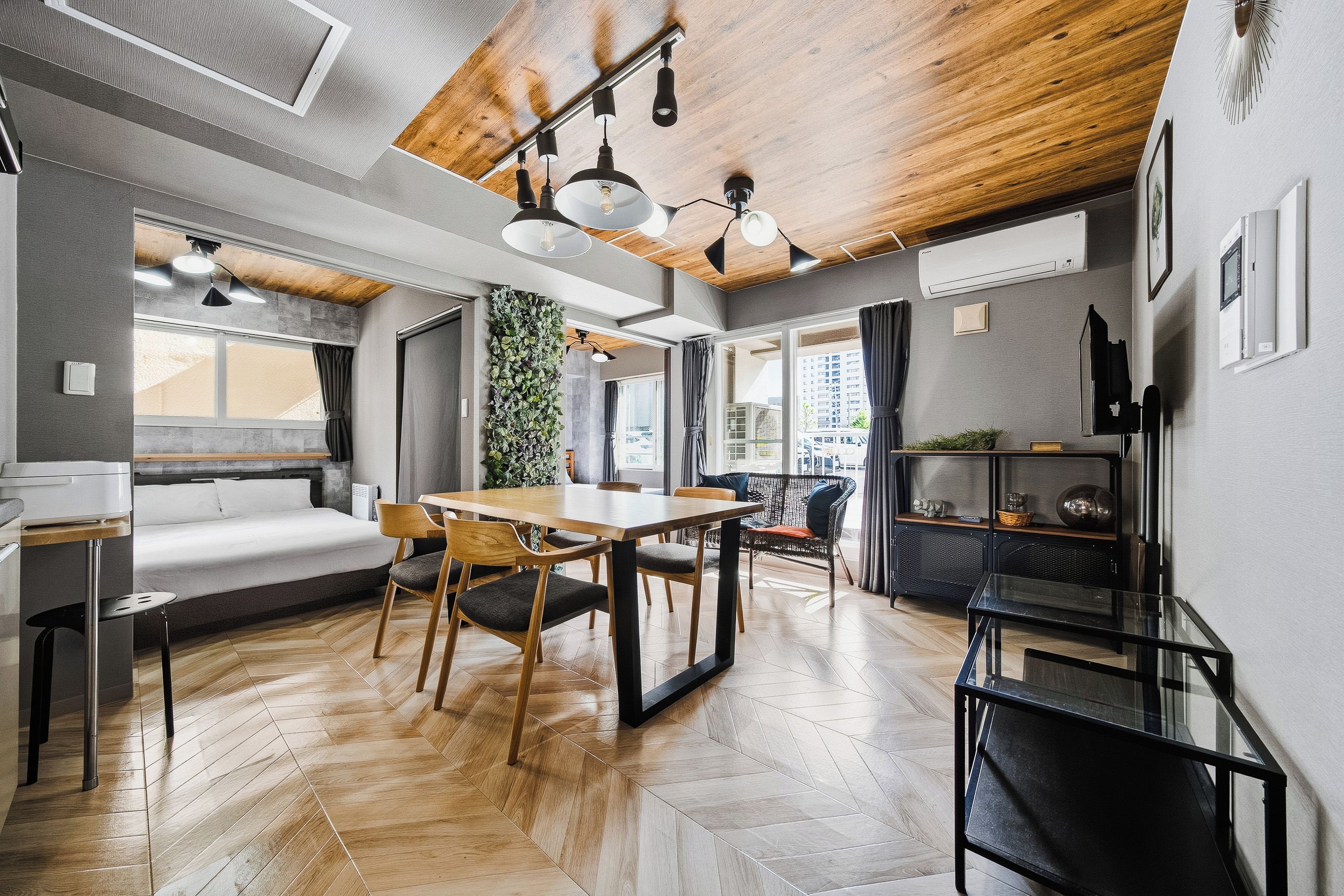 A modern interior with a dining area, a sofa, and a large window.