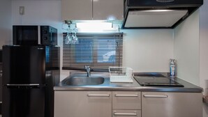 Eine moderne Küche mit Edelstahlgeräten, einem eingebauten Ofen und einem Fenster mit Jalousien.