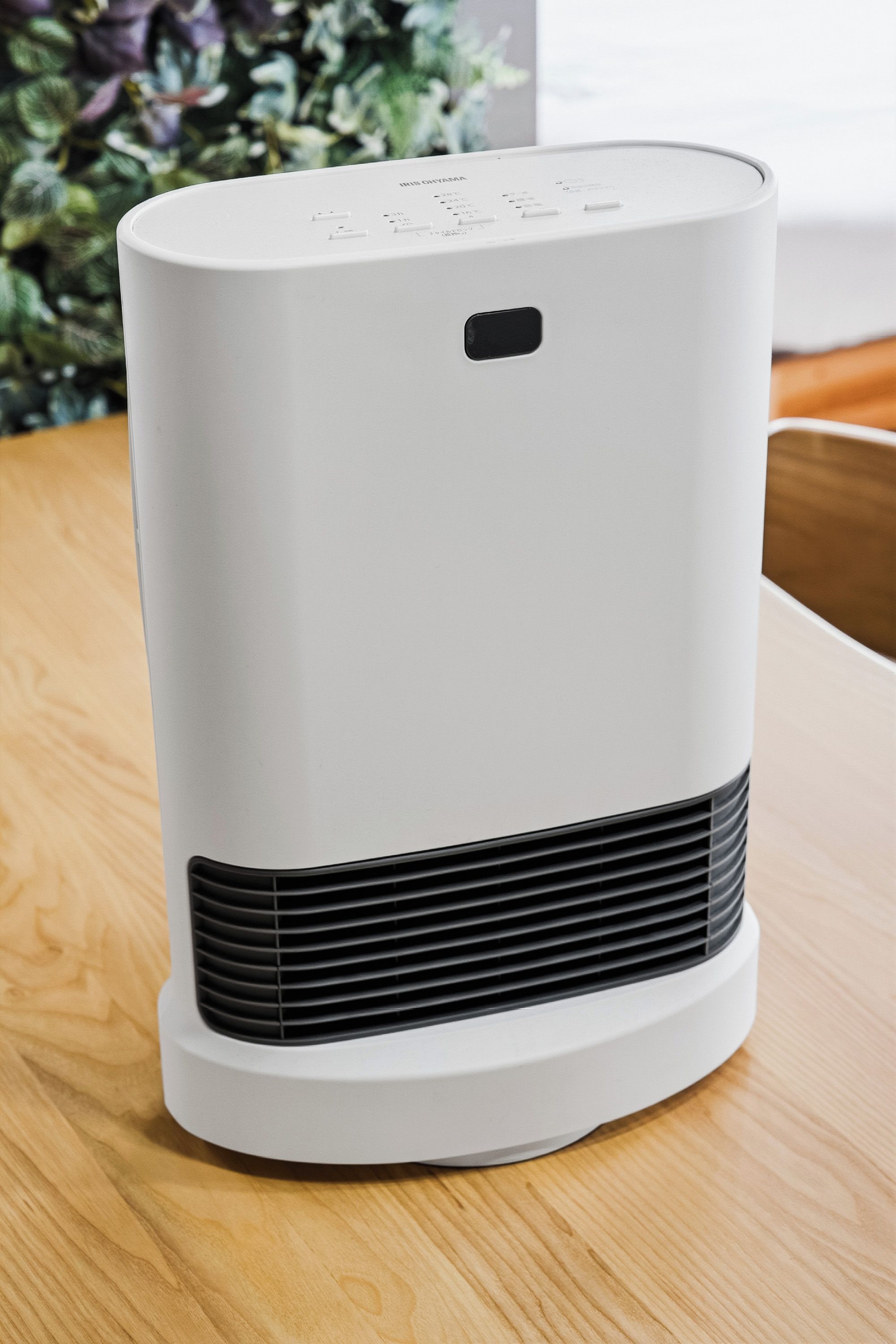 A white portable air purifier with a front vent and a control panel on top.
