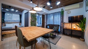 Ein modernes Wohnzimmer mit einem Holzesstisch, einer Couch und einem Fernseher.