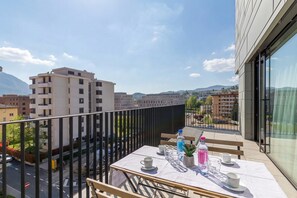 A balcony with a table set for two, a potted plant, and a bottle of water. - ICON H Lugano 401 Suite Business, Lugano, Switzerland (Lugano)