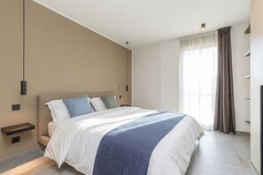 A modern hotel room with a large bed, bedside tables, and a window with curtains. - ICON H Lugano 401 Suite Business, Lugano, Switzerland (Lugano)