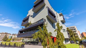 A modern multi-story building with balconies, a flat roof, and a clear sky. - ICON H Lugano 306 Suite Micro-Living, Lugano, Switzerland (Lugano)