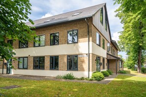 Un bâtiment moderne à deux étages, doté d’une façade en briques, de grandes fenêtres et d’une enseigne indiquant « St. Johns ».