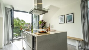 Una cocina moderna con una isla grande, estufa integrada y vistas al balcón.