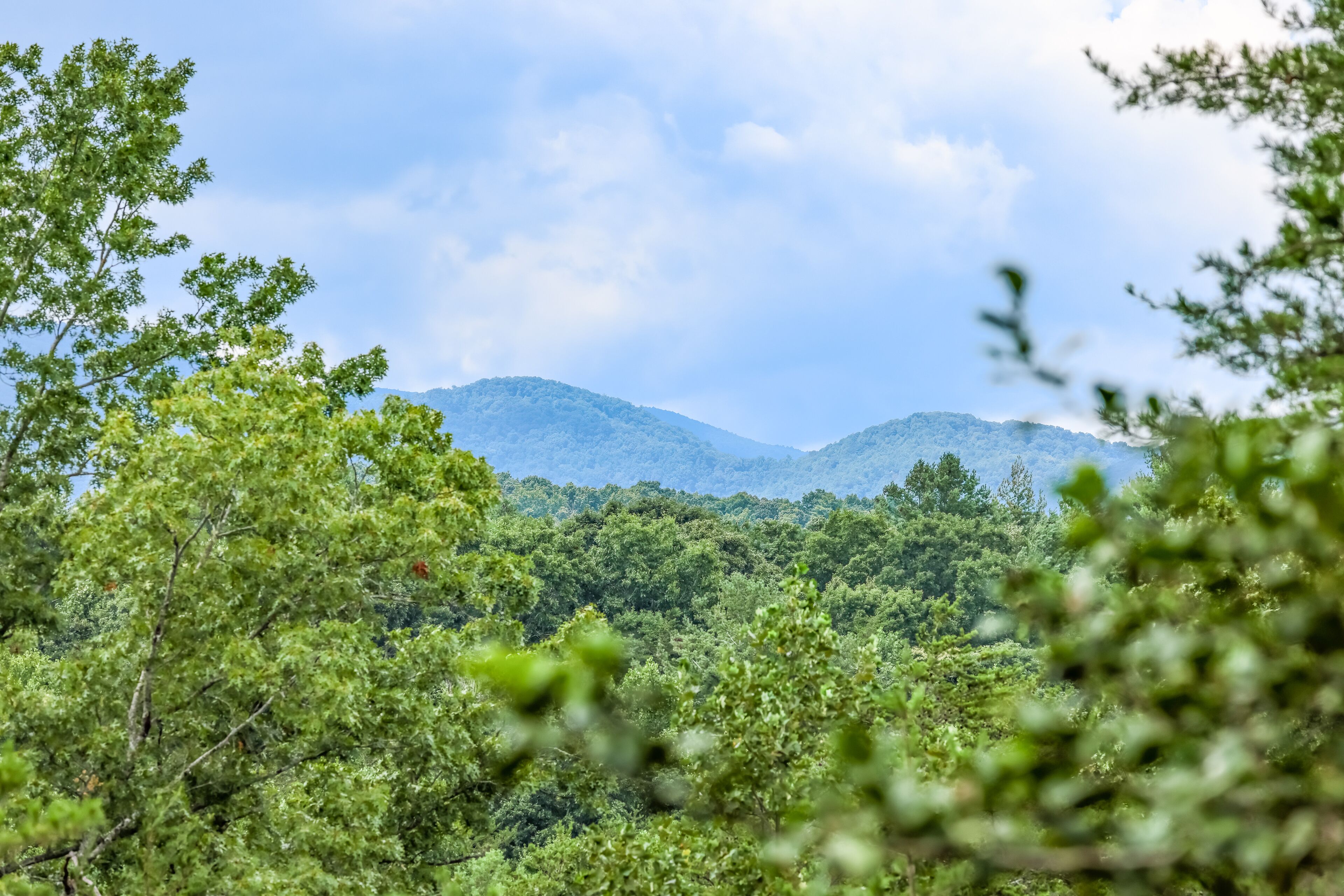 Modern mountain-view retreat with private deck, firepit, grill, fireplace, & W/D