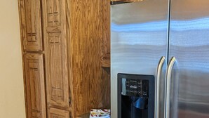 A kitchen with wooden cabinets and a stainless steel refrigerator with a water dispenser.