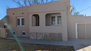 A two-story building with a stone foundation, multiple windows, and a garage.