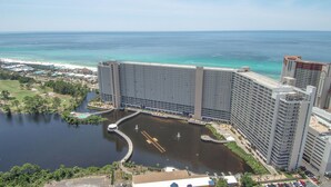 A large hotel with multiple high-rise buildings, a marina, and a beach in the background.