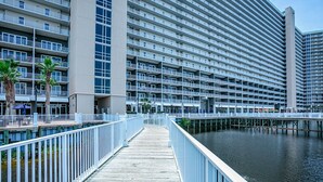 A waterfront hotel with a wooden boardwalk, multiple balconies, and a marina.