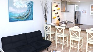 A modern kitchen with white brick backsplash, stainless steel appliances, and a bar area with white bar stools. - Perfect Escape From Home / Hogar Lejos De Casa (Miami)