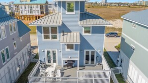A multi-story building with a balcony and outdoor seating area. - Family Friendly Beach House in Gated Beach Resort (Galveston)