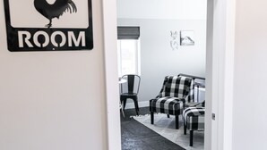 A room with a sign reading "CHICKEN COOP ROOM," a checkered rug, and a lamp. - Barn  Stay (Hurricane)